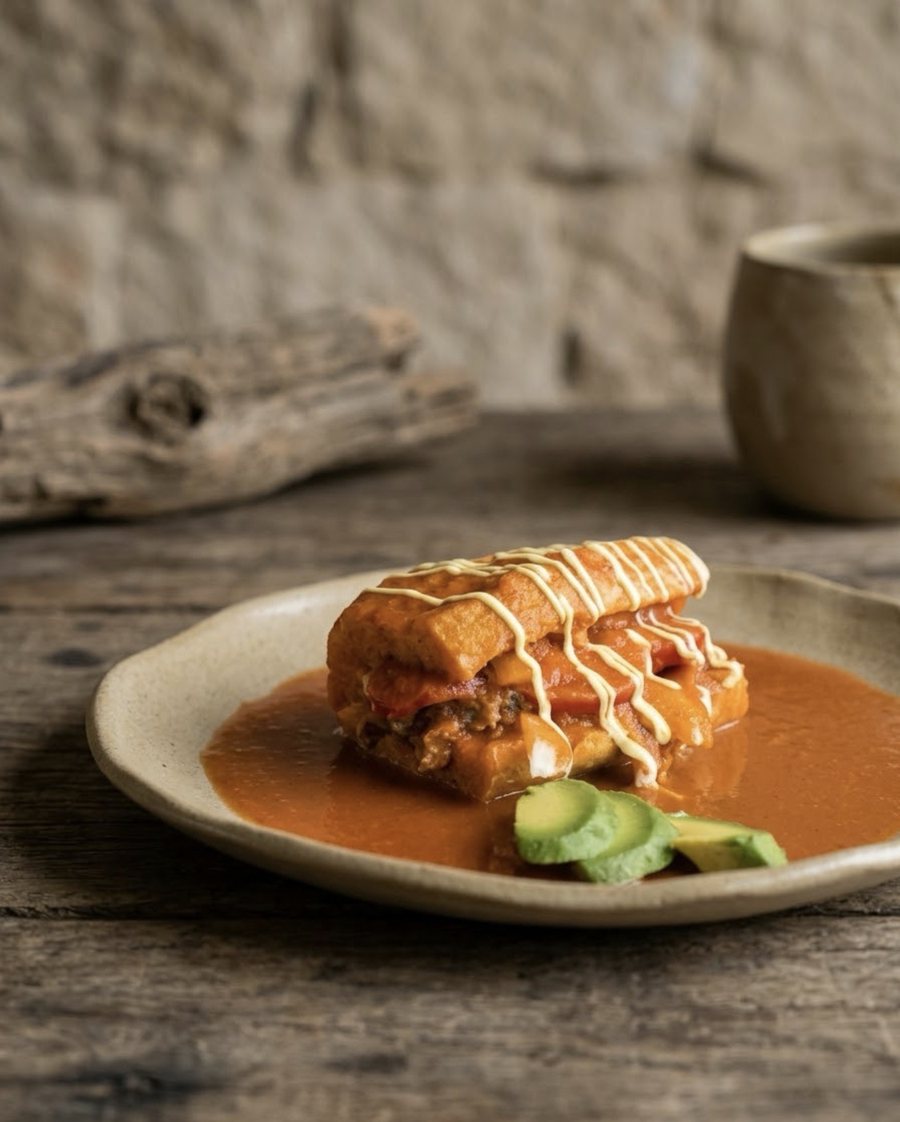 Lonche bañado en salsa con aguacate